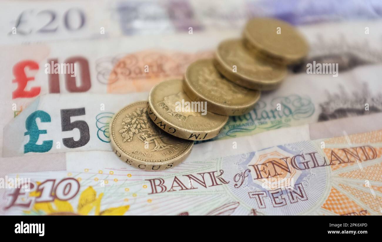 File photo dated 18/09/2012 of a general view of some UK pound coins and banknotes. More than 80% of families struggled to pay utility bills last year, despite Government intervention, a survey has shown. About 3,000 families have responded to the Child Poverty in Action Group's (CPAG) rolling survey on the impact of the UK Government's two-child limit on social security benefits, such as universal credit and tax credits, since 2019. Issue date: Thursday April 6, 2023. Stock Photo