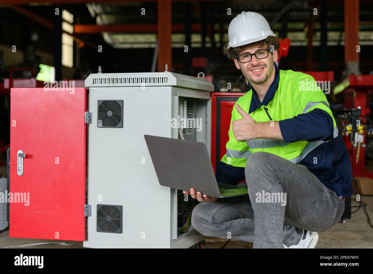 Professional male technician worker in white helmet checking machine maintenance Stock Photo
