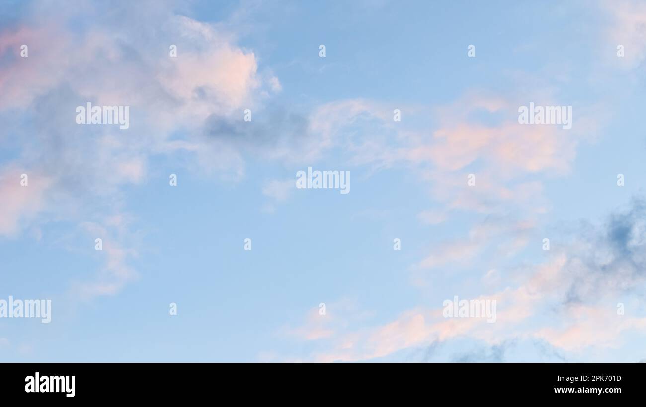 Background of blue sky with pale pink clouds at sunset Stock Photo - Alamy