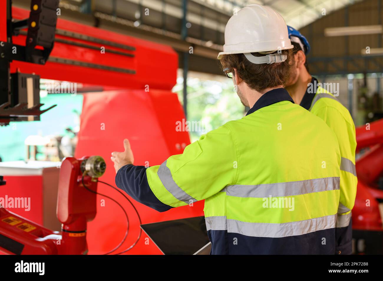 Two technicians workers with safety uniform using laptop talking Stock Photo