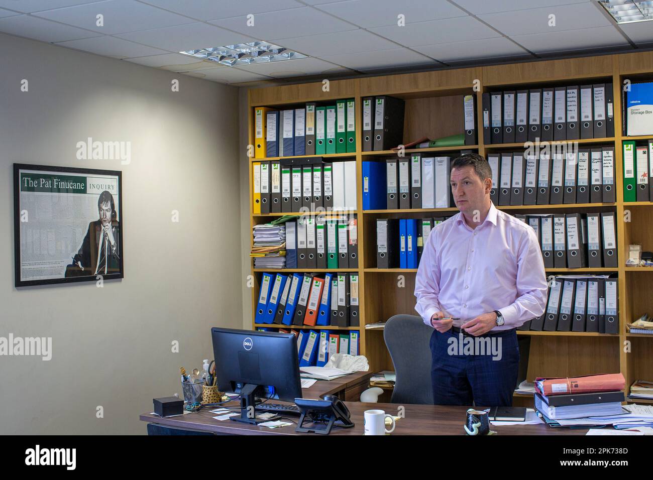 John Finucane , Irish lawyer and Sinn Féin politician with a photo of his father lawyer Pat Finucane, who was murdered in 1989 at his family home by l Stock Photo