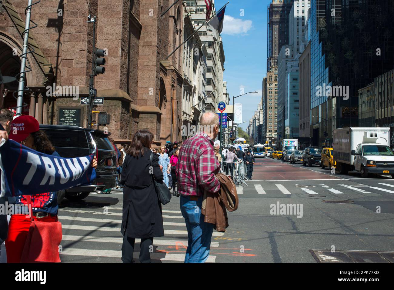 Supporter of President Trump holds Trump sign while standing on busy 55th St and 5th Ave NYC. morning of Trump arraignment, 04 April 2023. Stock Photo