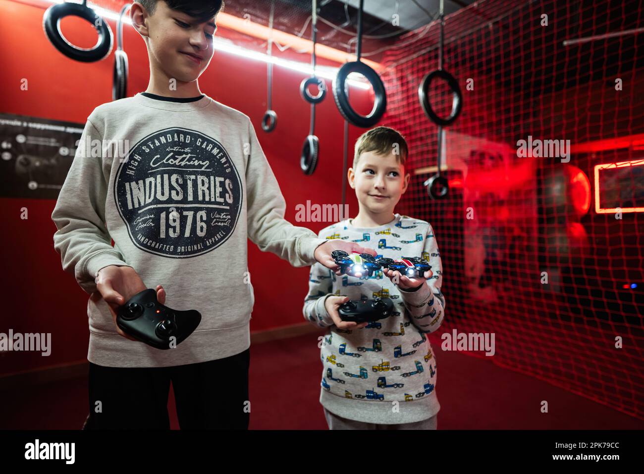 Children flying remote control drones game indoor play zone Stock Photo
