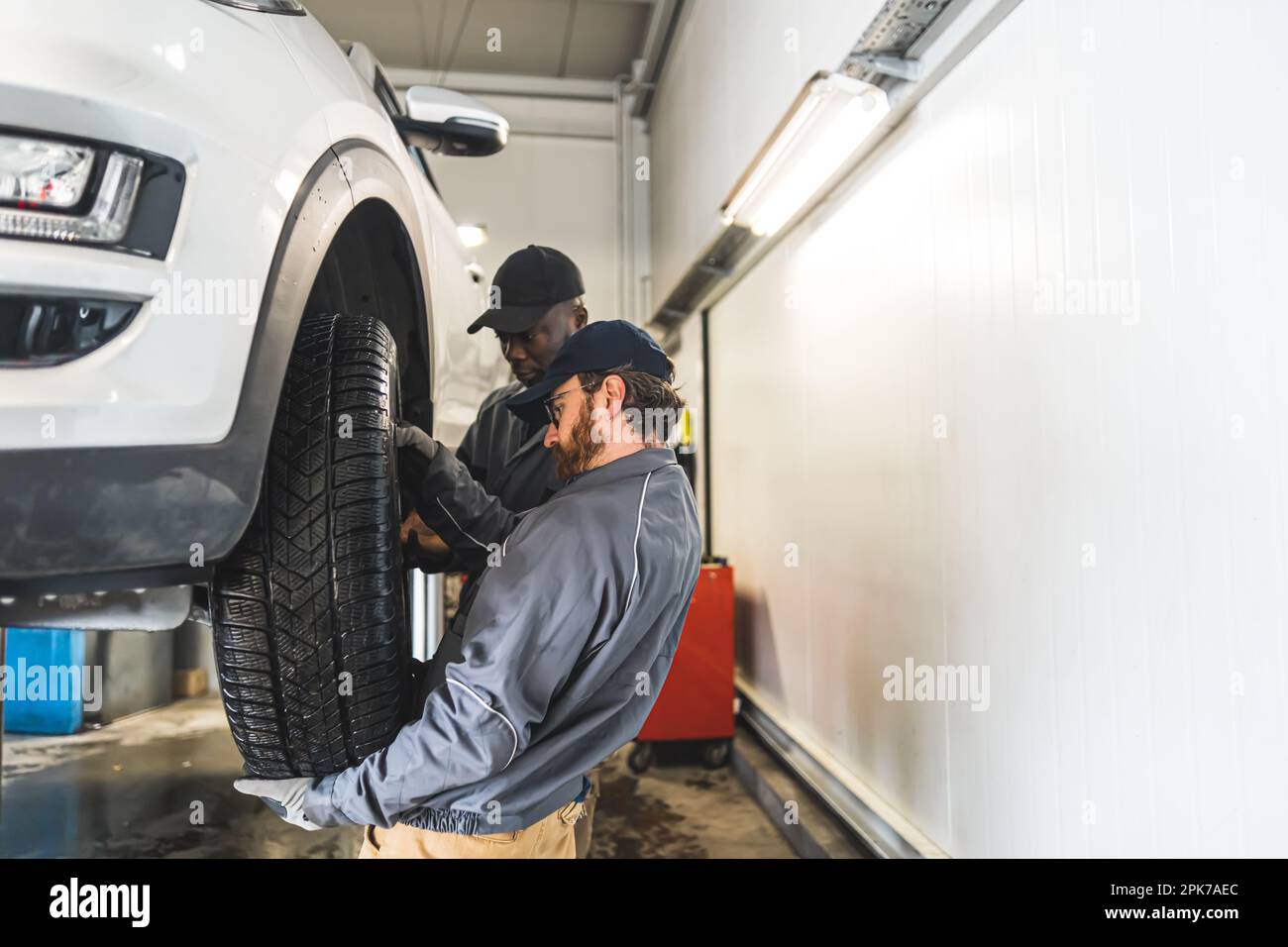 professional mechanics changing a wheel on the car, car repair concept. High quality photo Stock Photo