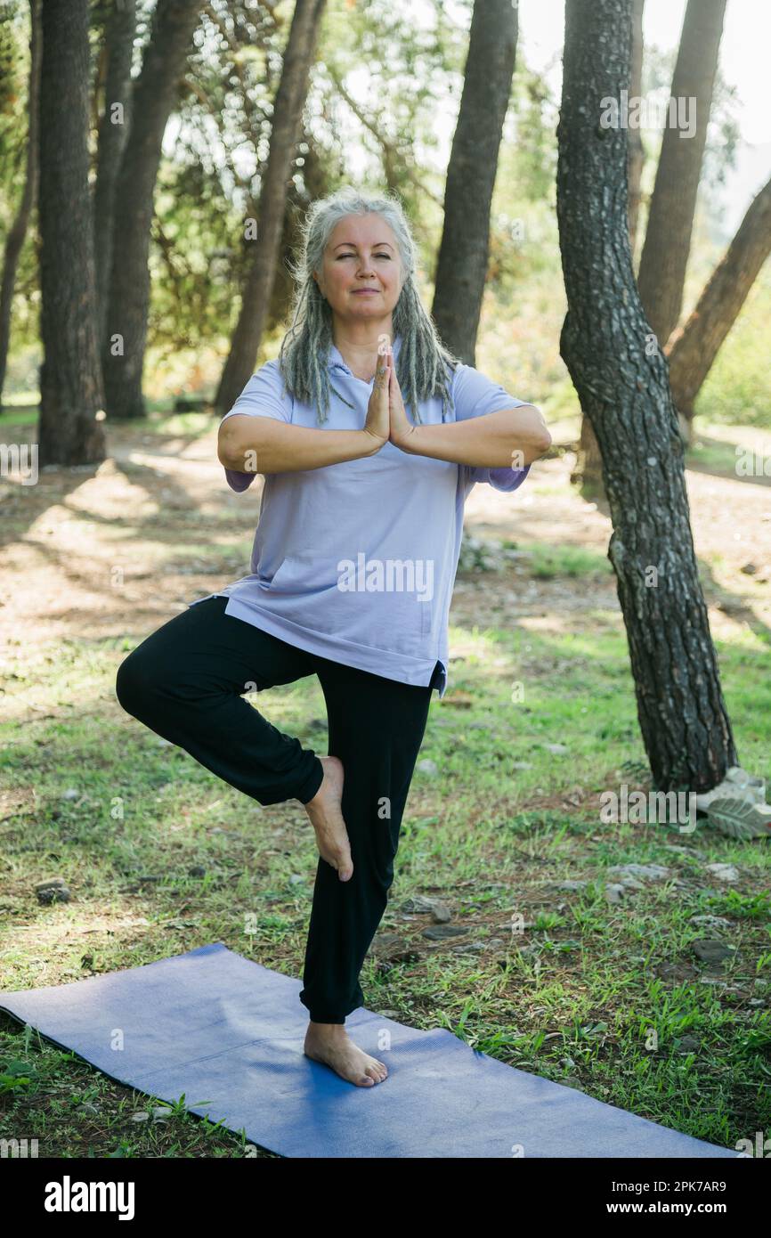 Mature old woman with dreadlocks practicing yoga and tai chi outdoors -  wellbeing and wellness Stock Photo - Alamy