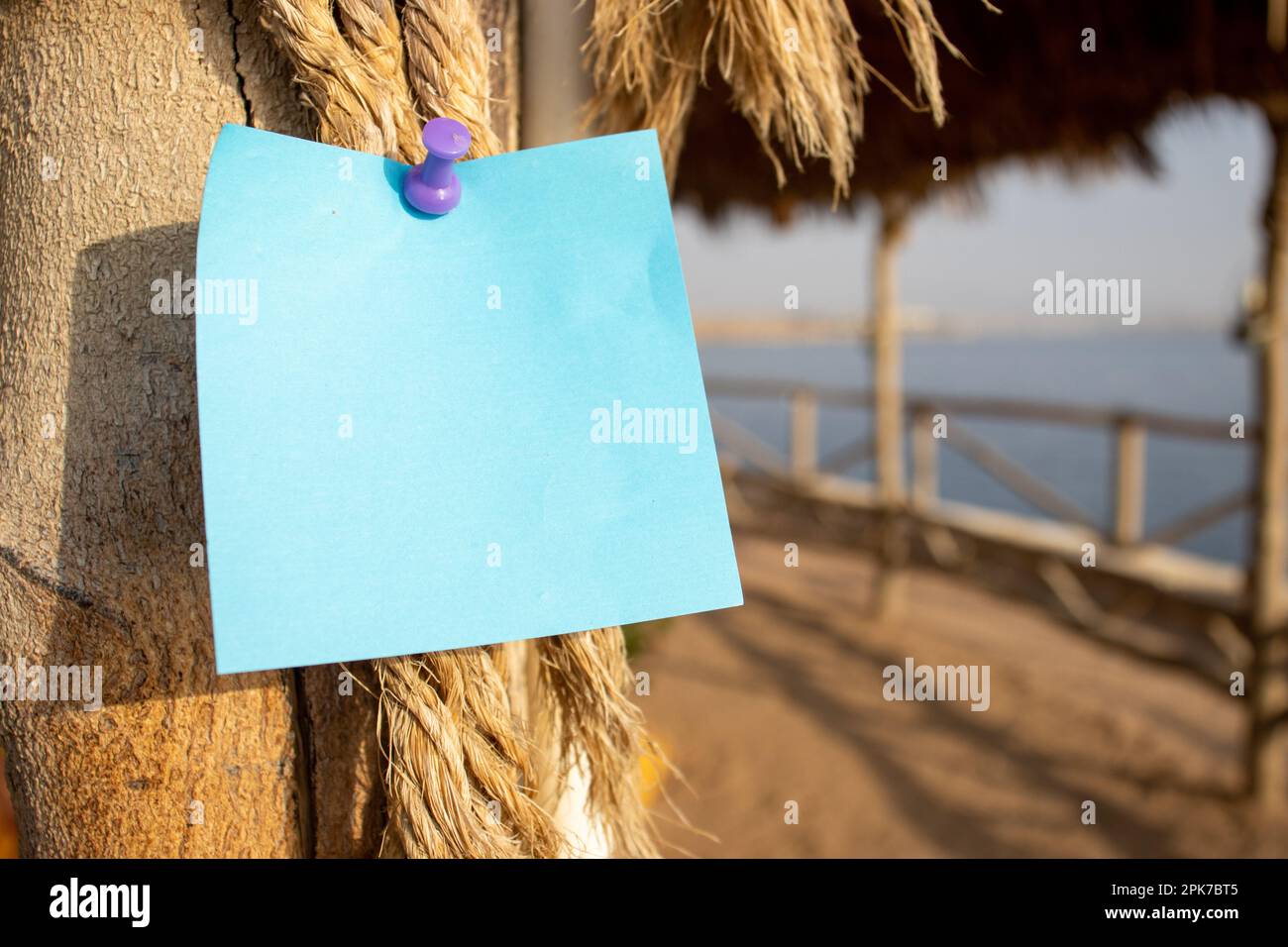 rope with wooden post and a blue square paper note with empty free ...