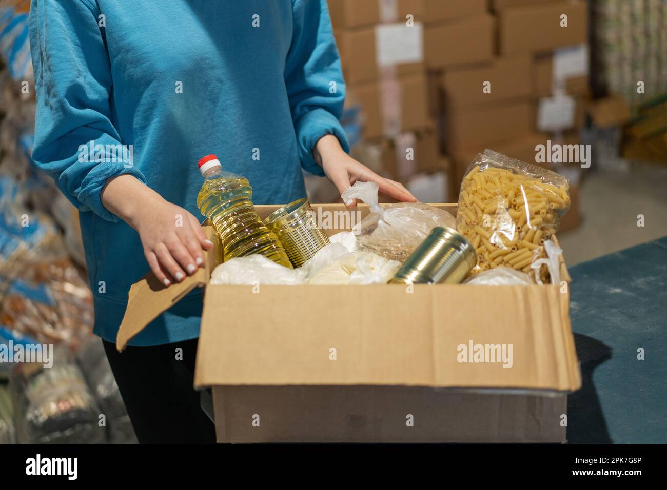 Volunteer girl preparing donation boxes for people. Donation clothing
