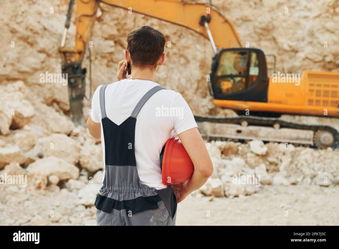 Operator is working on the borrow pit. Man in professional uniform