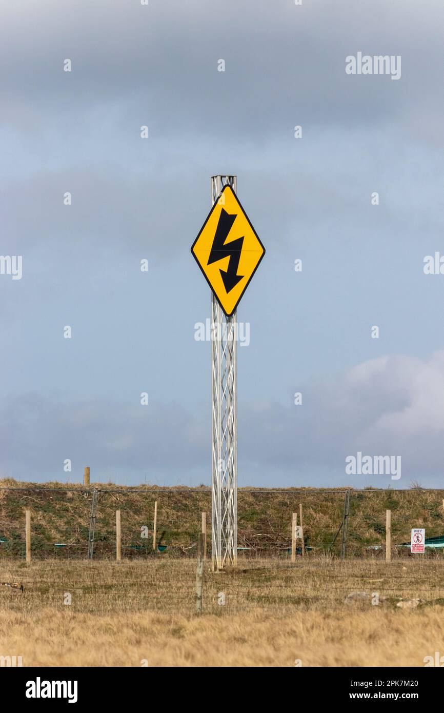 A warning sign for high voltage electricity in a field near Wick, Scotland Stock Photo