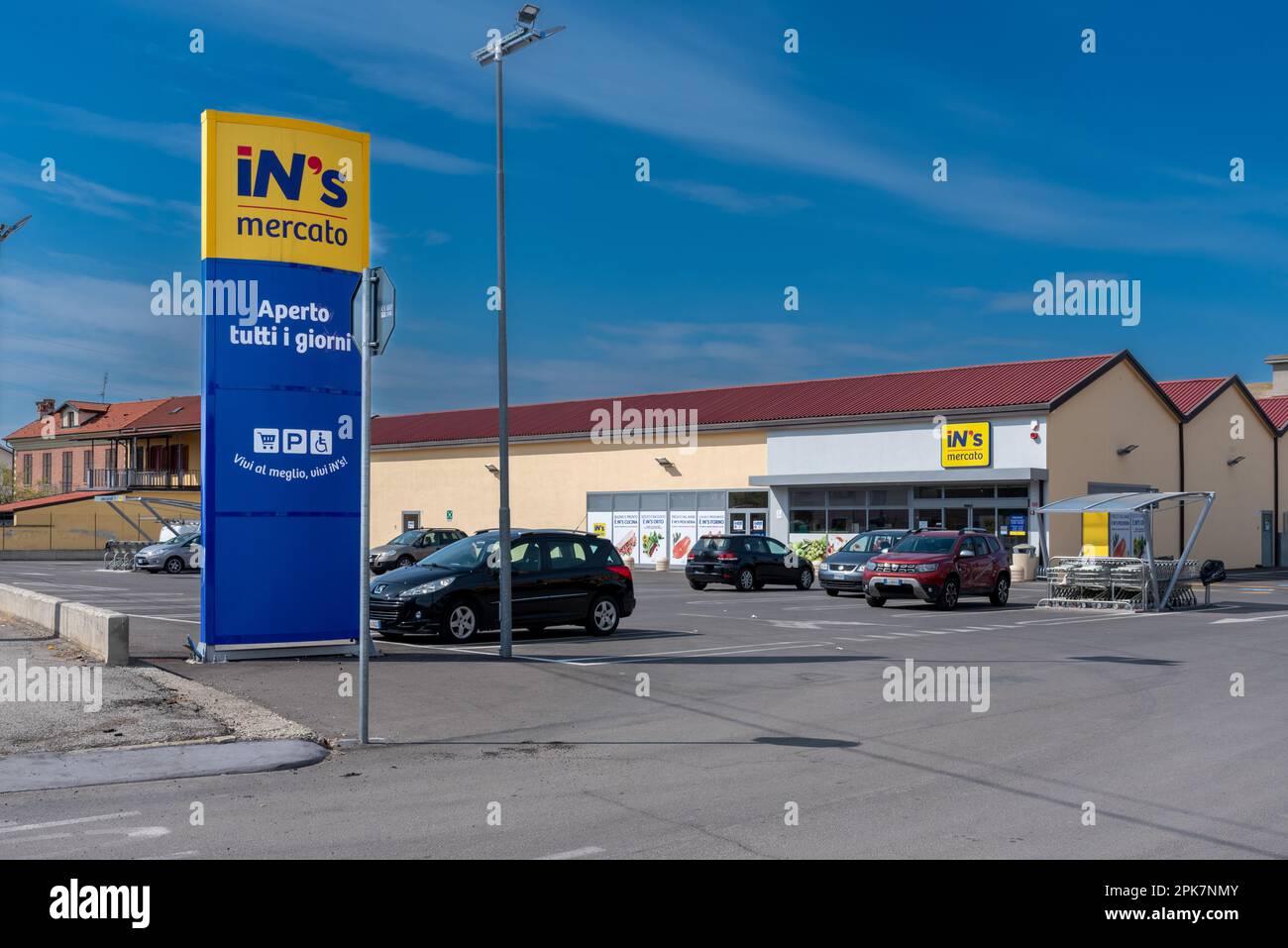 Sommariva Bosco, Cuneo, Italy - April 05, 2023: Exterior view of the INS Mercato supermarket with totem sign with INS logo on blue sky with clouds, IN Stock Photo