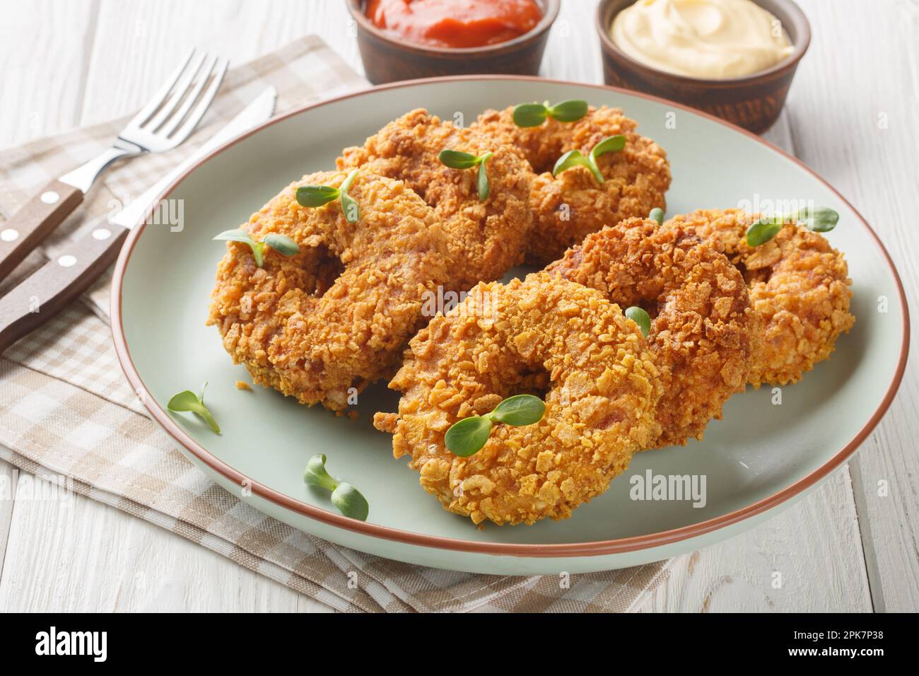 Fried crispy breaded chicken donuts close-up on a plate on the table. Horizontal Stock Photo
