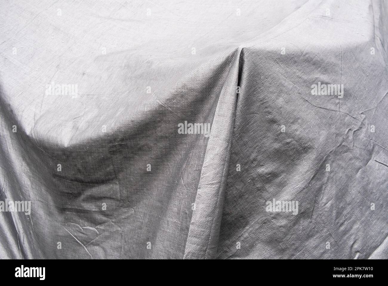 Black and white image, folds of tarpaulin draped across objects. Stock Photo