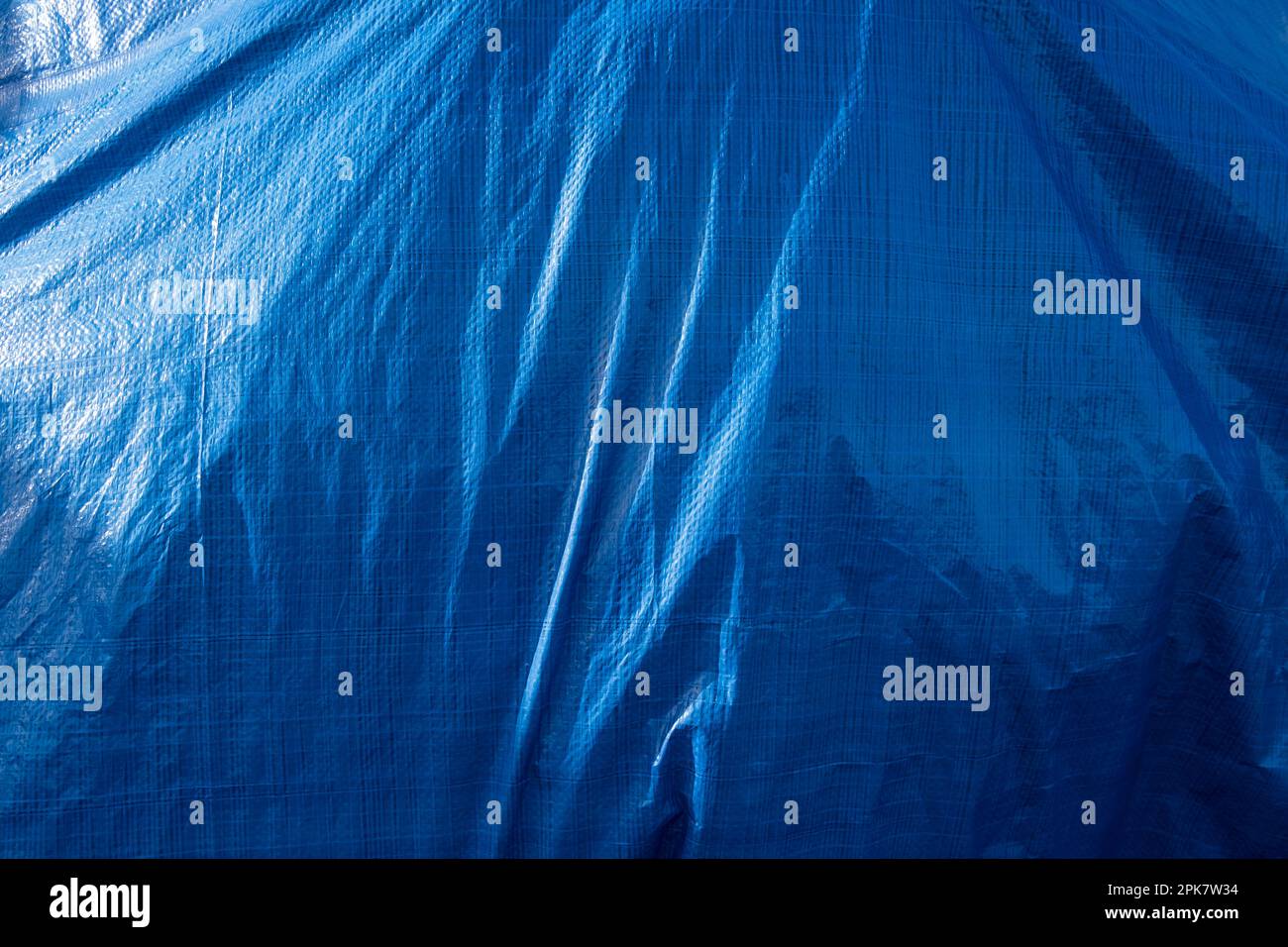 A blue tarpaulin covering a hidden object. Stock Photo