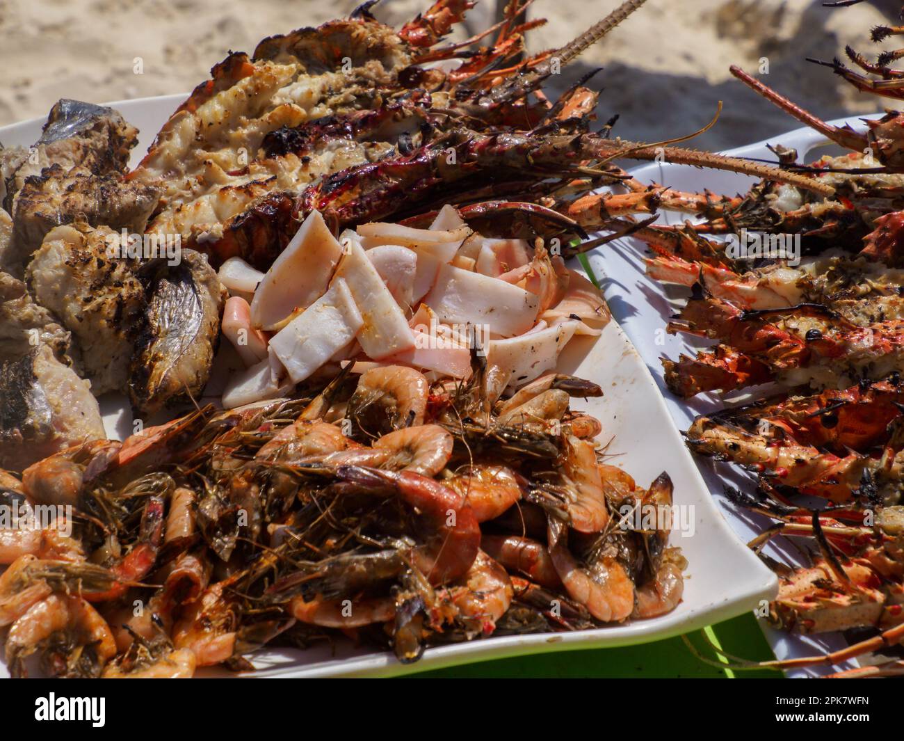 Grilled seafood served during a Blue Safari to sandbank in Menai Bay with beautiful sandy beach and lazure water, Zanzibar archipelago, Africa, Zanzib Stock Photo