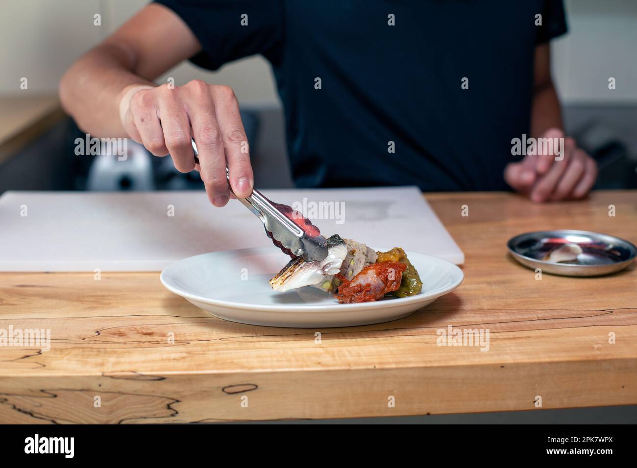 A chef preparing plates of tapas food in a restaurant. Stock Photo
