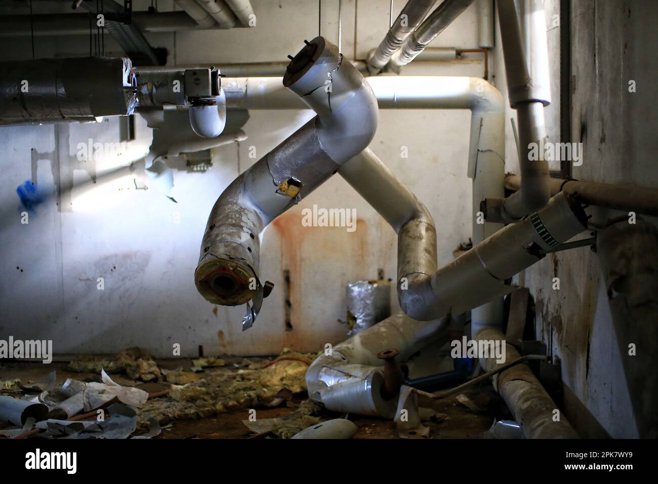 Broken heat pipes hanging bizarrely in a basement Stock Photo Alamy