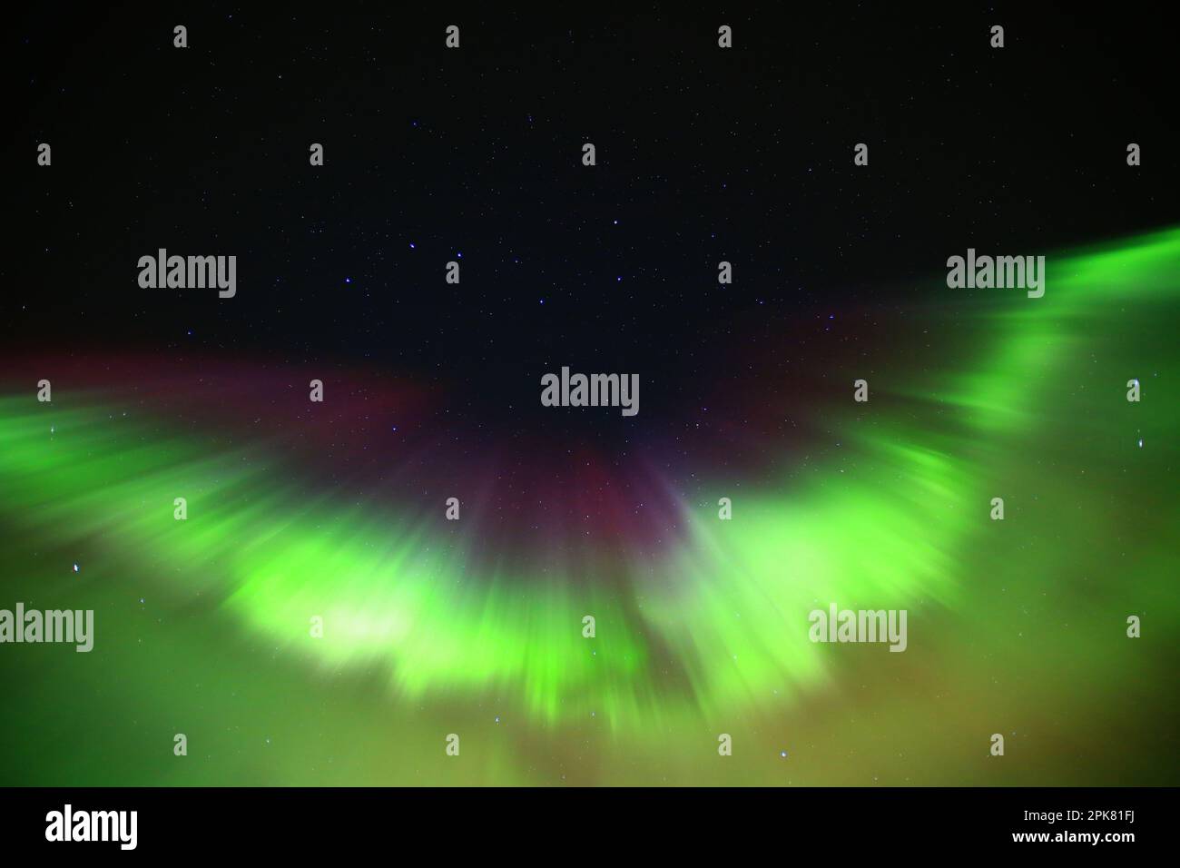 Green and purple aurora formation on starry sky. Stock Photo