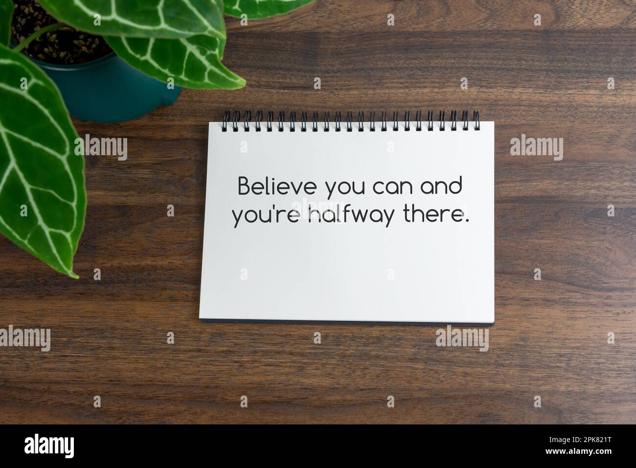 Short inspirational quotes text on note pad - Believe you can and you're halfway there. Stock Photo