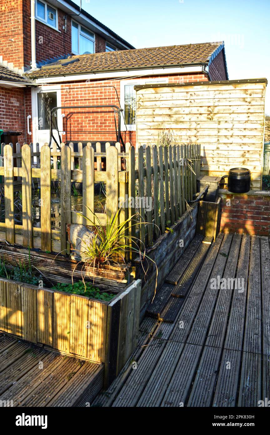 Fish pond on decking surrounded with a wooden fence Stock Photo
