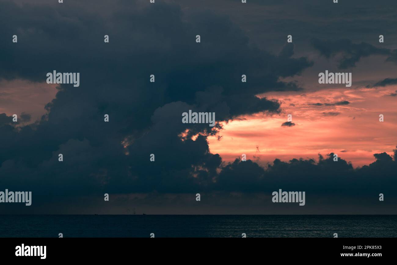 Dark cloudy tropical sunset sky over the ocean, natural background
