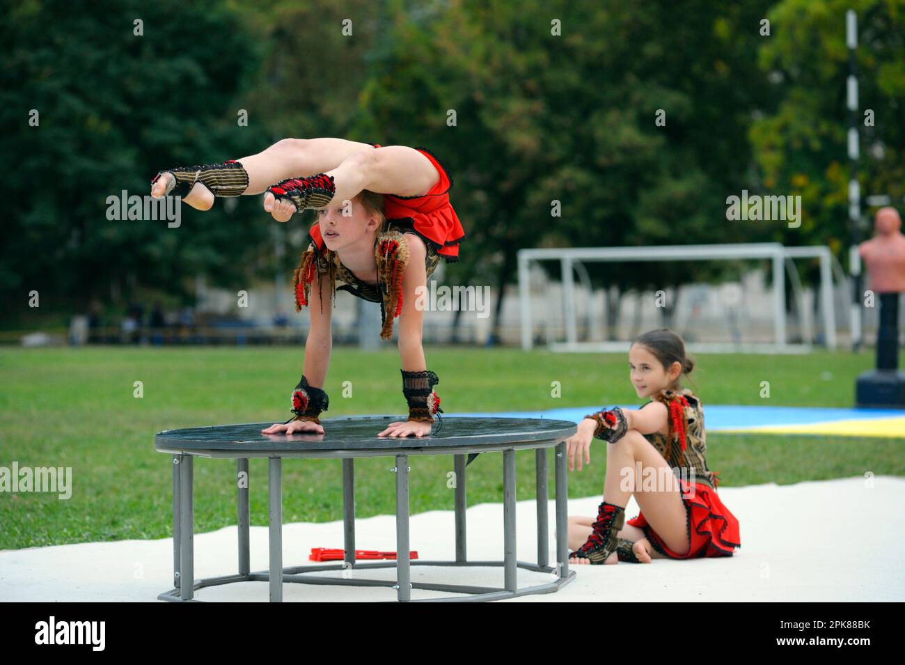 Group of little girls acrobats doing acrobatic tricks on a football field. Opening the University of physical culture and sport. June 20, 2019. Kyiv, Stock Photo