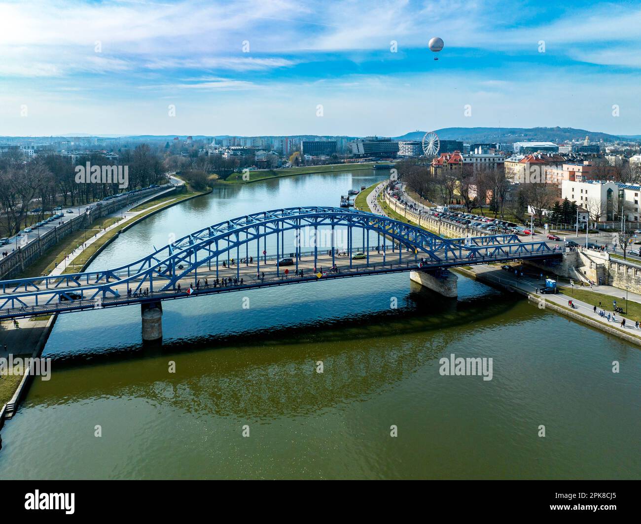 Krakow, Poland. Blue Pilsudski tied-arc bridge, observation and tourist balloon over Vistula River and far view of a Ferris wheel Stock Photo