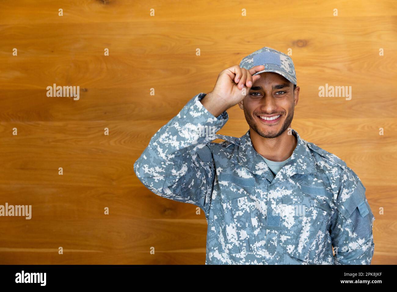 Portrait of happy biracial male soldier wearing uniform, looking at