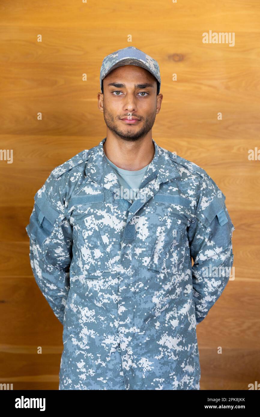 Portrait of biracial male soldier wearing uniform and cap, looking at
