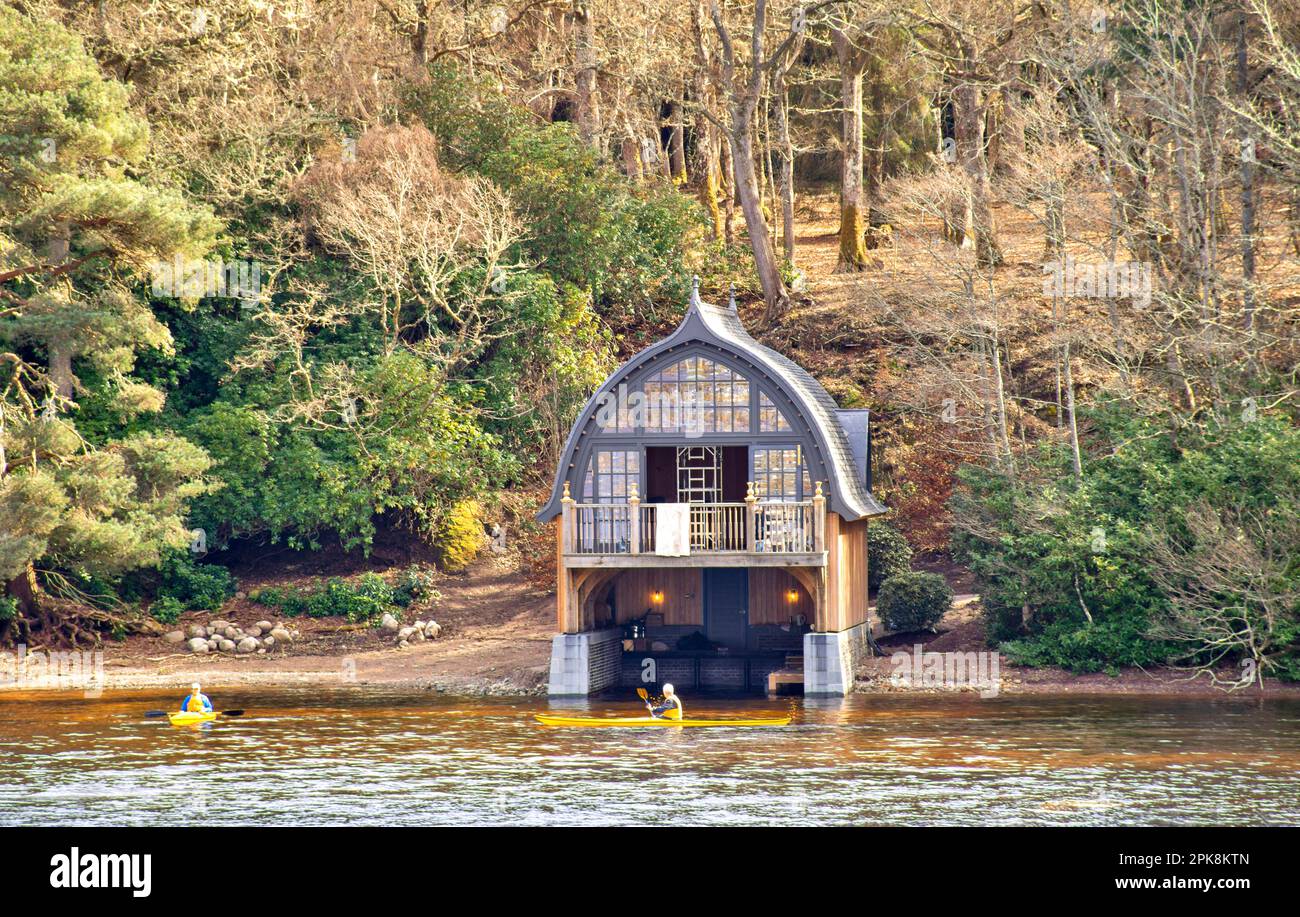 Aldourie Castle Estate Loch Ness Scotland the elaborate boat house as seen from the Loch and two yellow kayaks Stock Photo