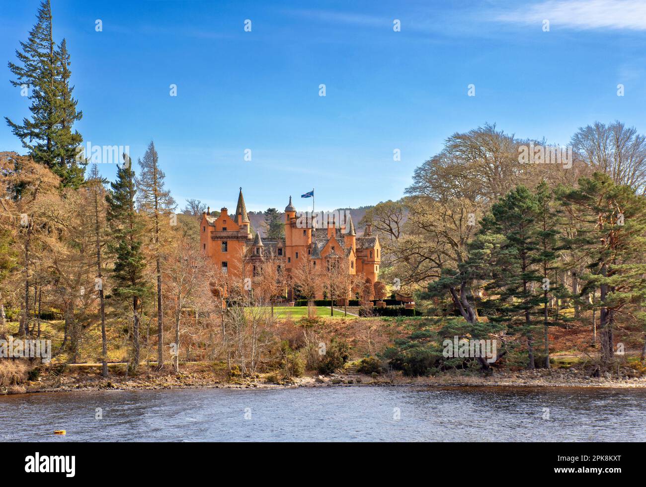 Aldourie Castle Estate Loch Ness Scotland the large castle building complete with turrets seen from the Loch Stock Photo