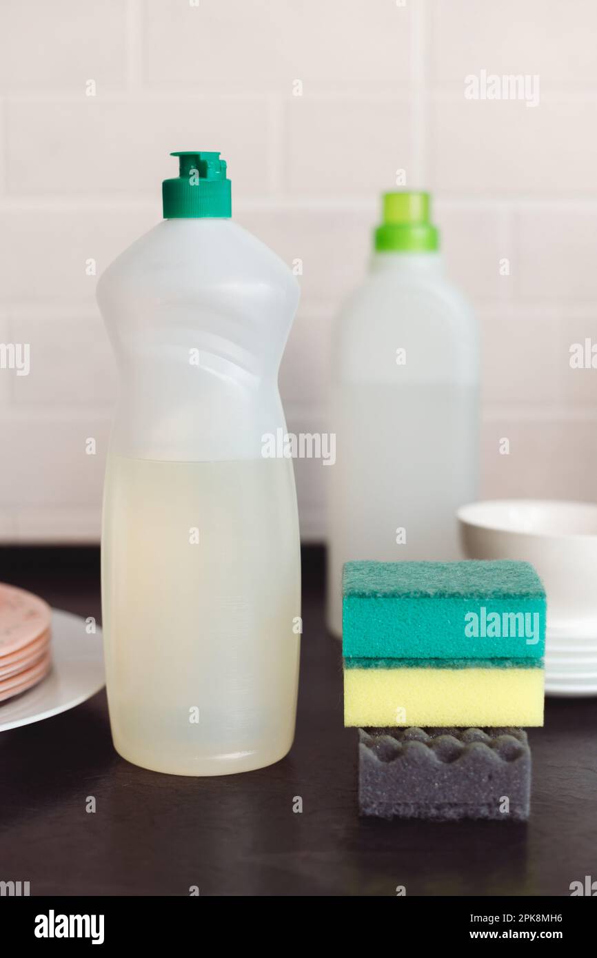 https://c8.alamy.com/comp/2PK8MH6/blank-plastic-bottle-with-liquid-dishwashing-detergent-gloves-sponges-and-stack-of-dishes-on-kitchen-table-copy-space-2PK8MH6.jpg