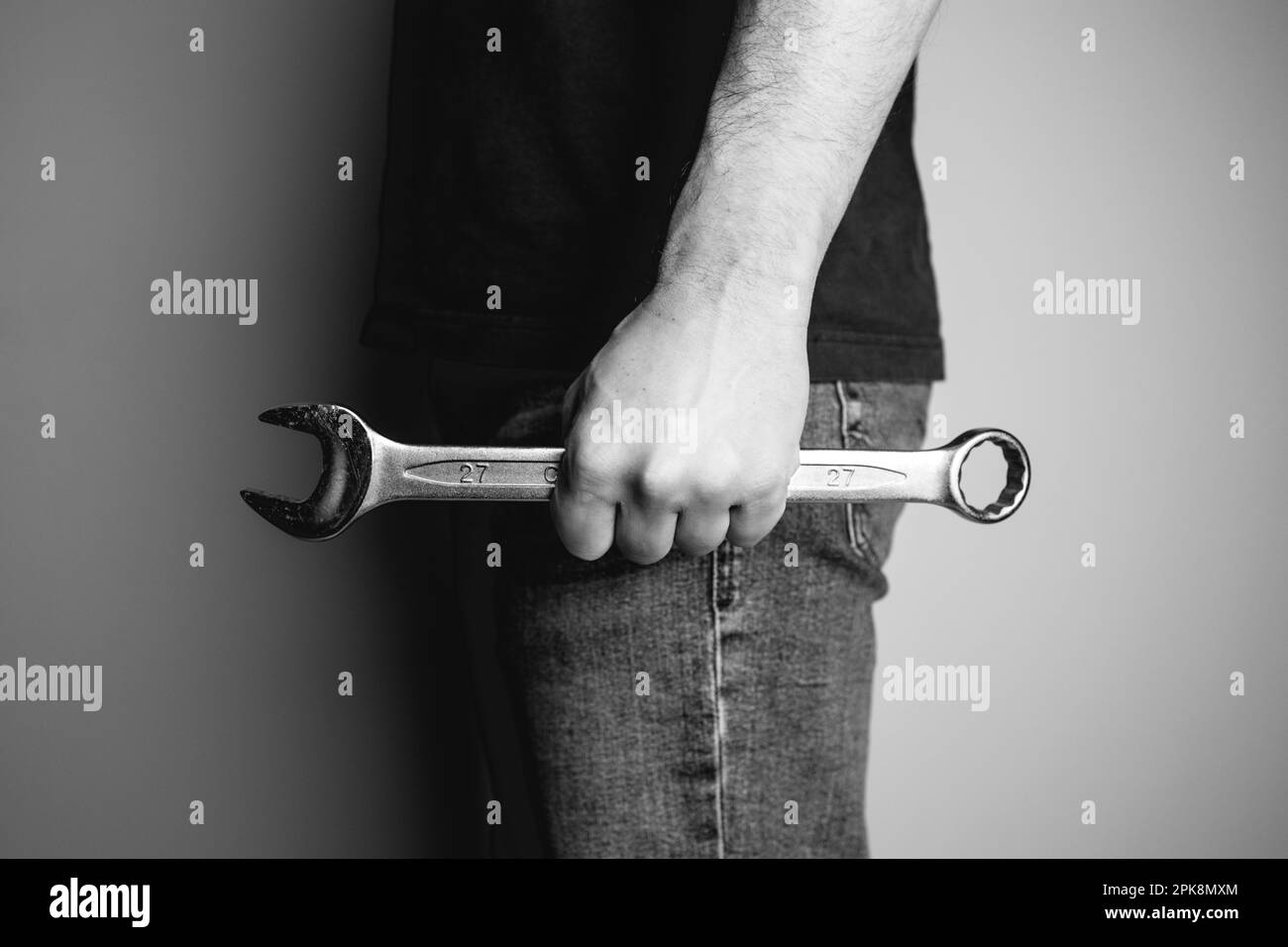 Man holding wrench in one hand. Side view. Ideal for industrial