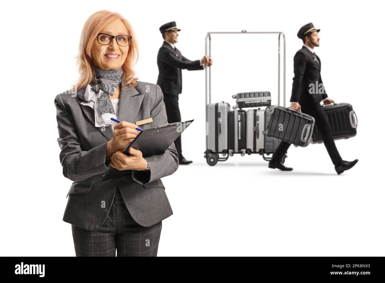 Bellboys carrying suitcases and female hotel manager writing a document isolated on white background Stock Photo