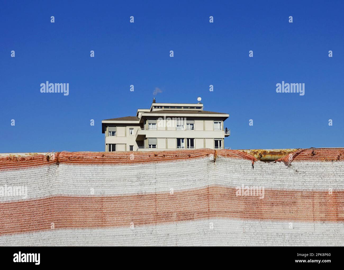 Behind Building new apartment building behind a construction site net Stock Photo - Alamy