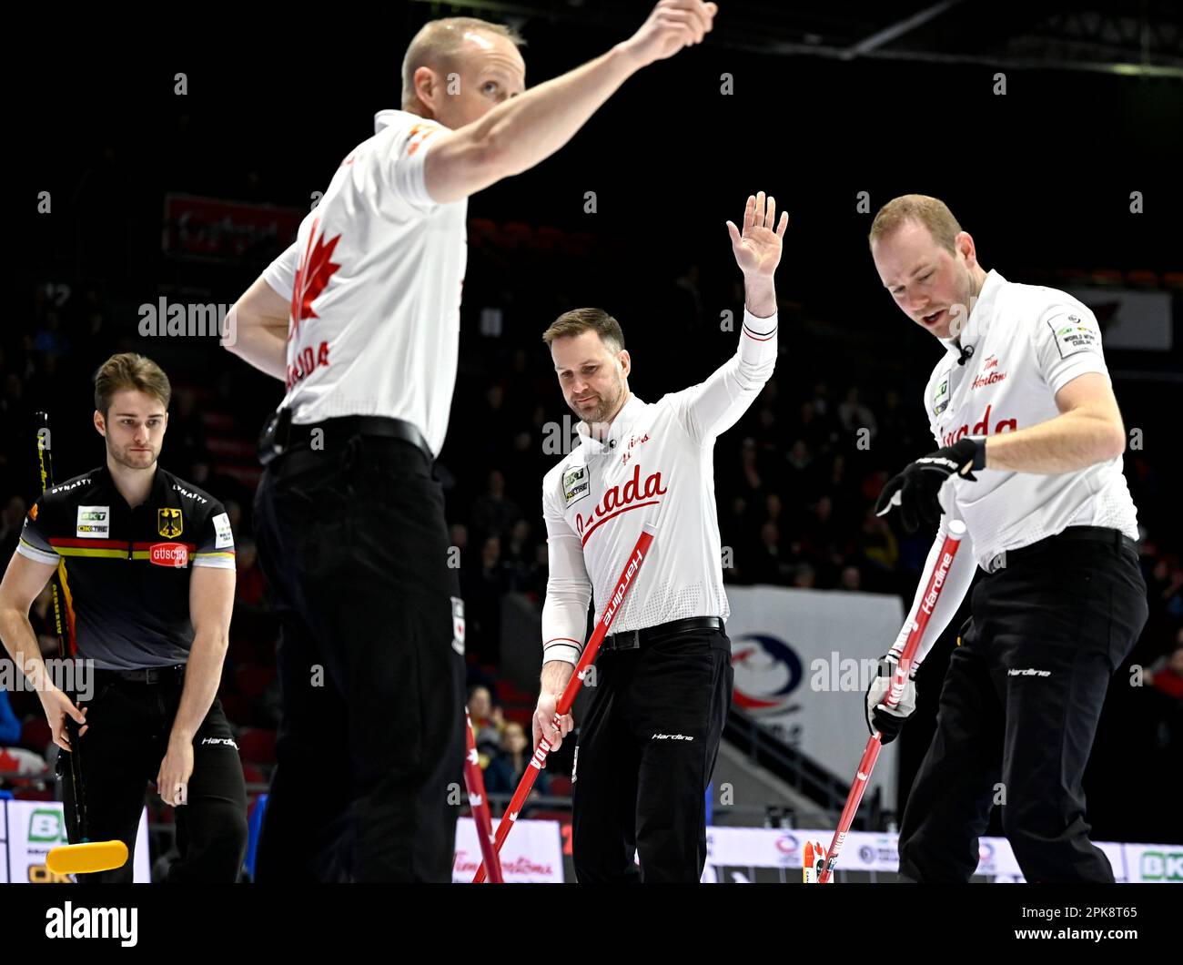 Canada skip Brad Gushue, second from right, waves towards second E.J