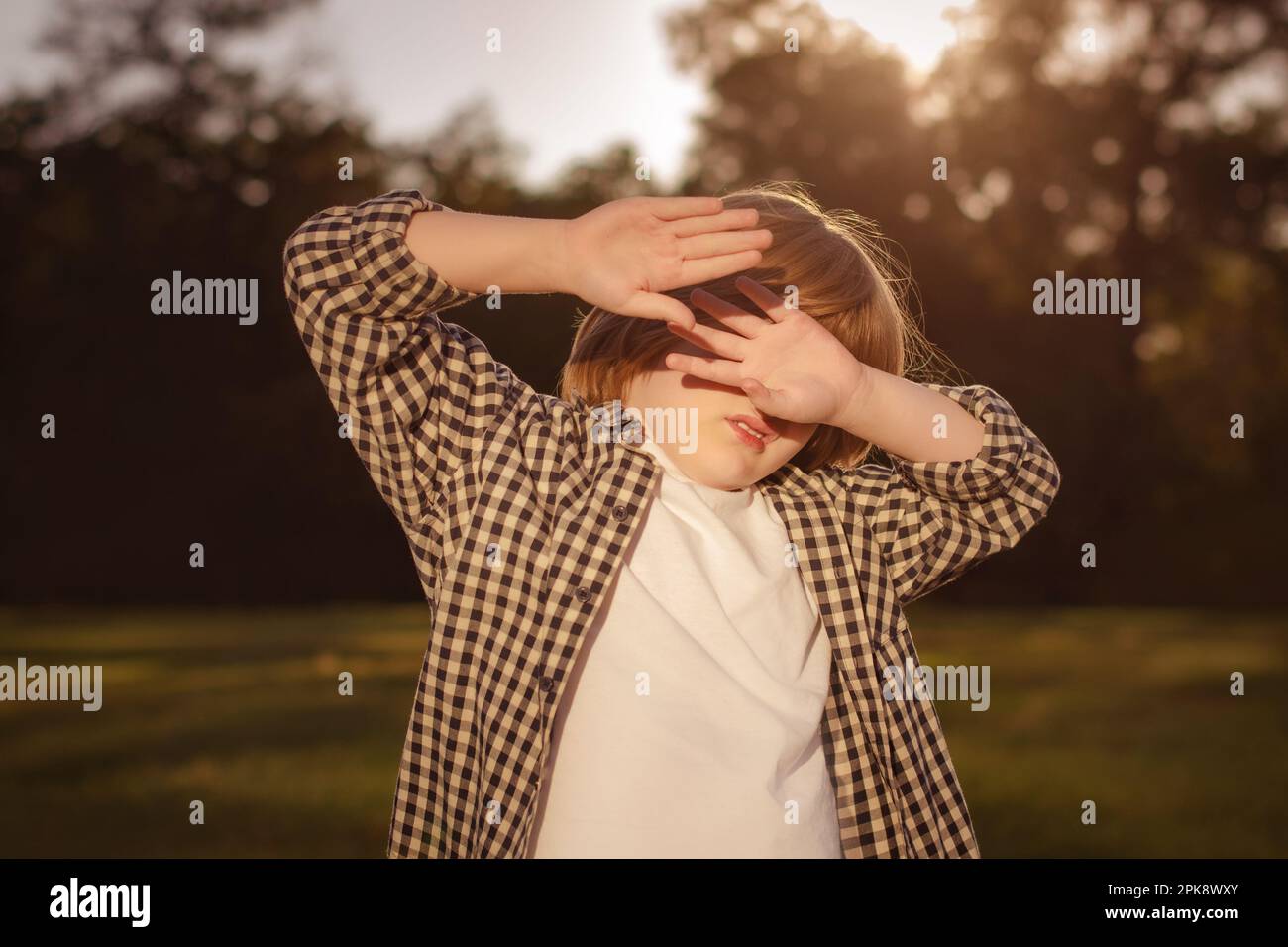 Photophobia Light Sensitivity content. Boy covering eyes by hand from