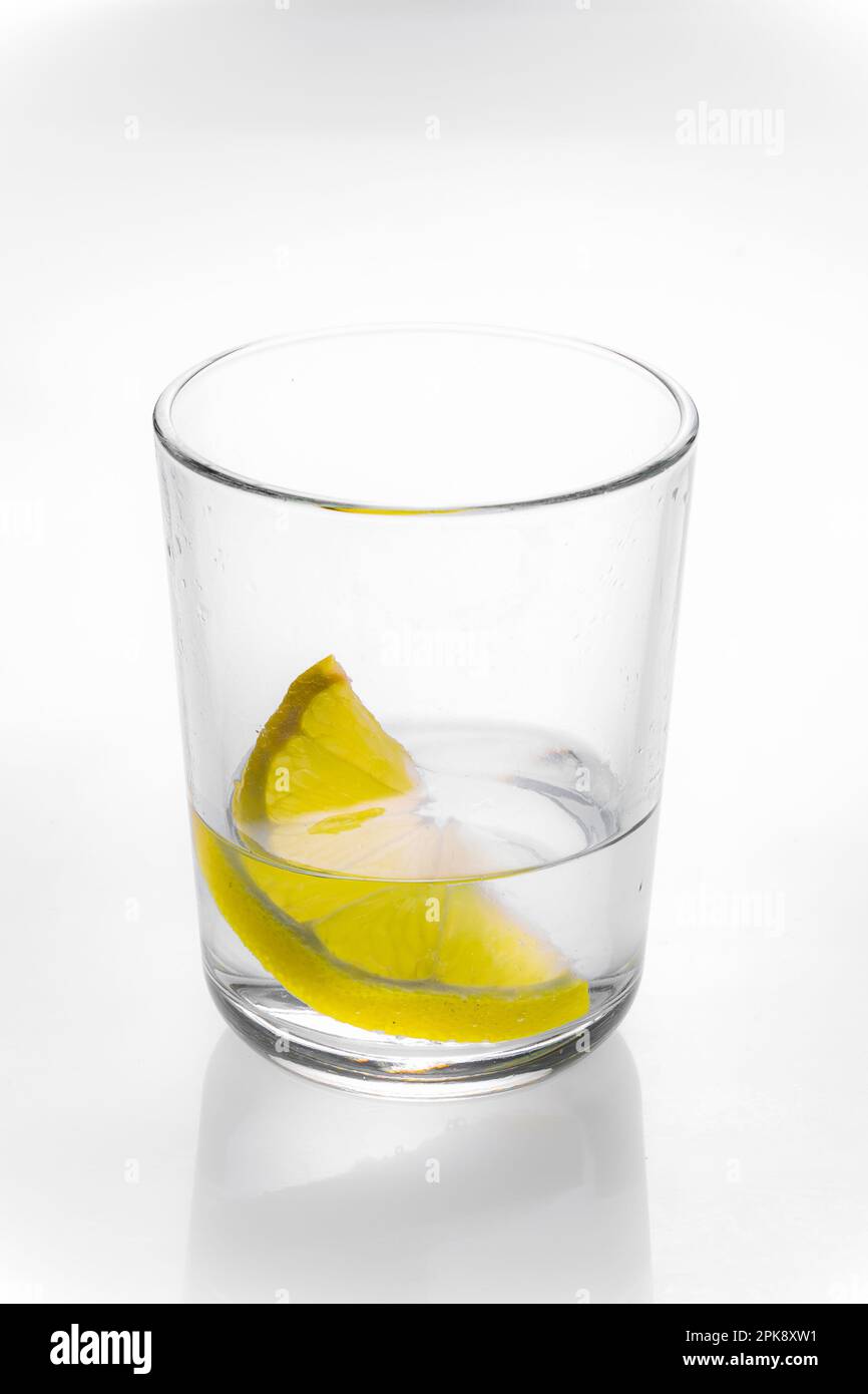 essenundtrinken-frisches klares wasser im glas mit einem spritzer zitrone  minze als sommerliche erfrischung zm trinken und geniessen Stock Photo