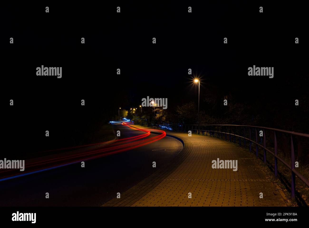 Light trails from a car's taillights at night Stock Photo