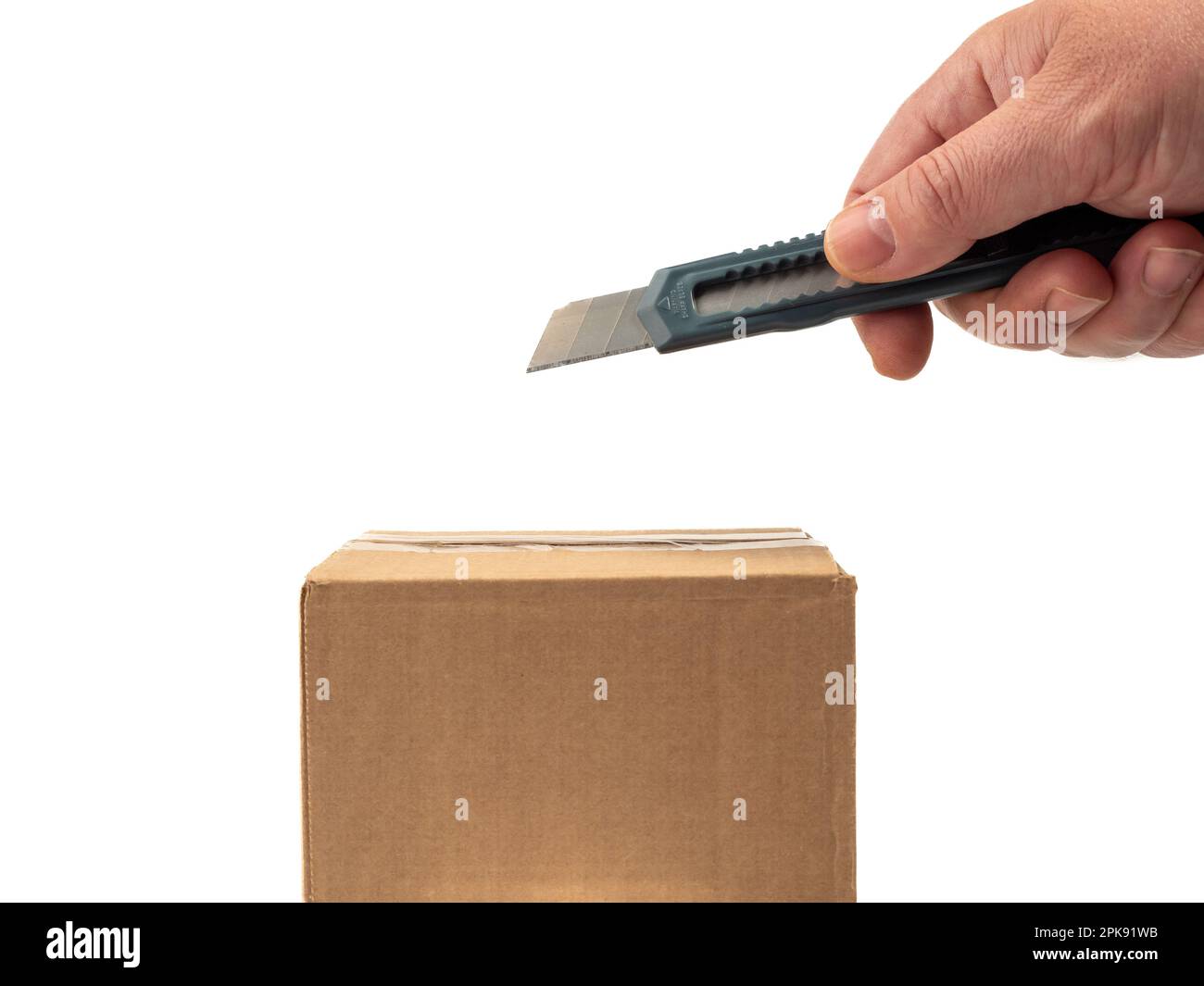 The cardboard box is opened with a knife. White background Stock Photo