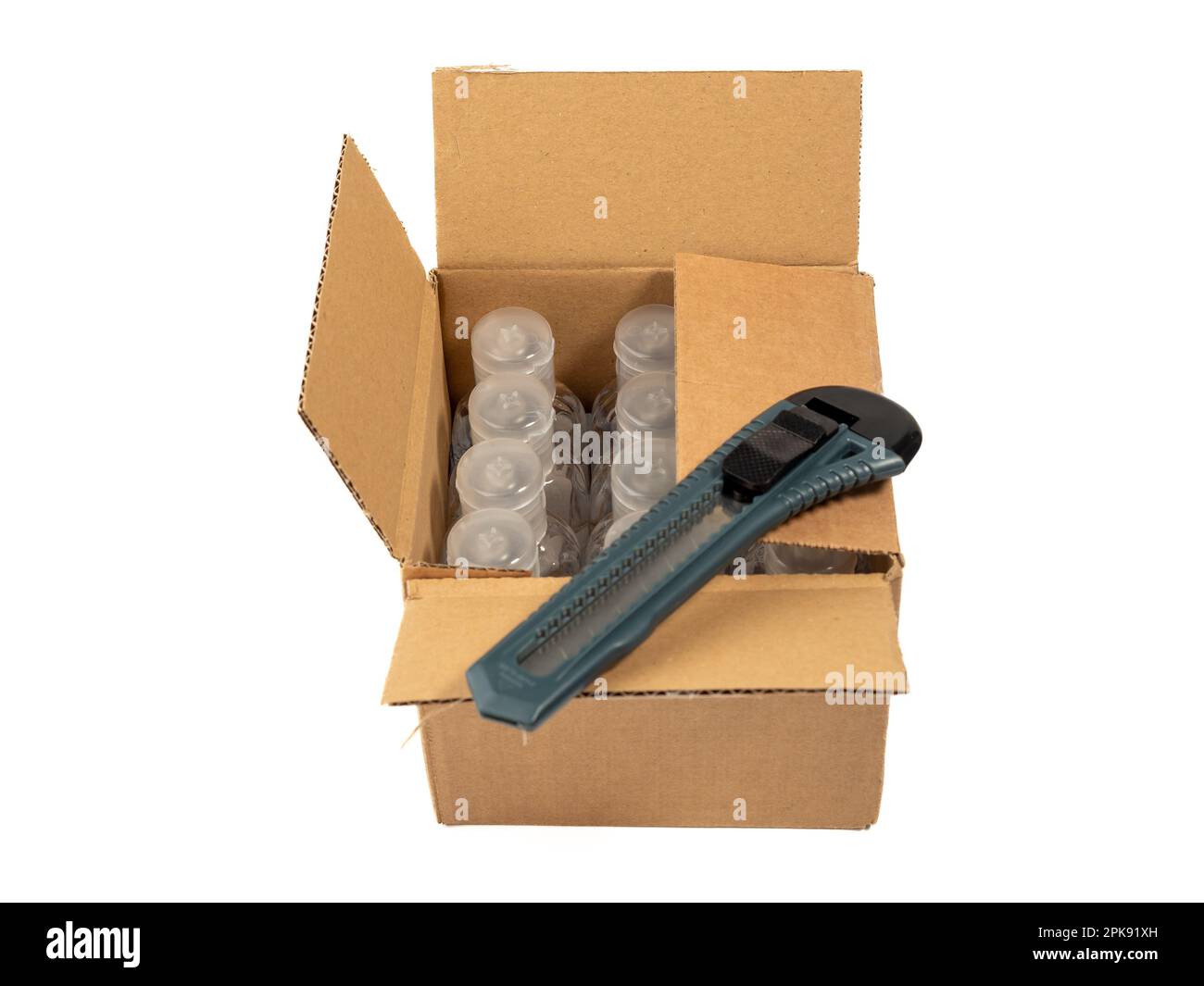 The cardboard box is opened with a knife. White background Stock Photo