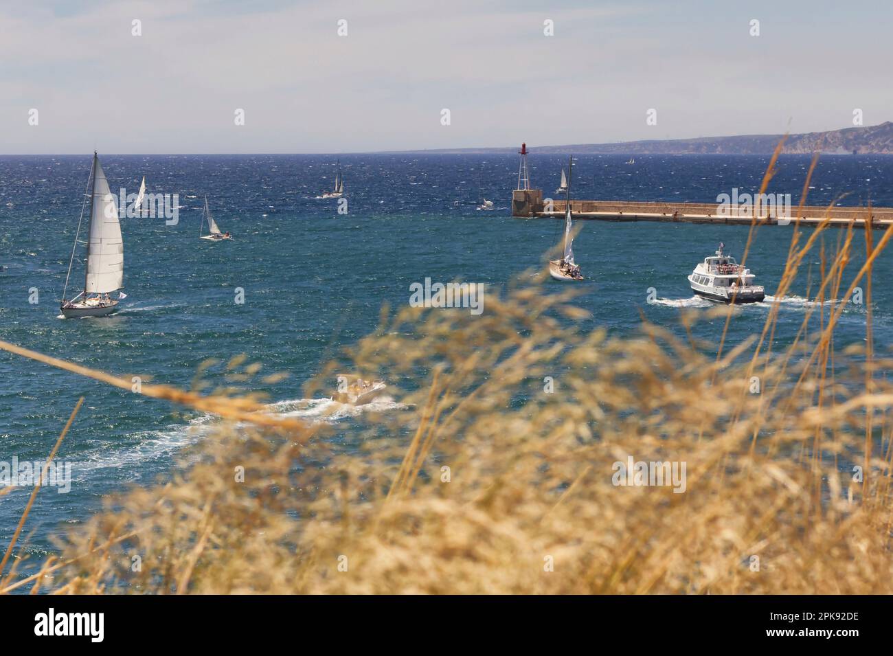 View over costline of Marseille on a sunny day with several boats on windy sea Stock Photo