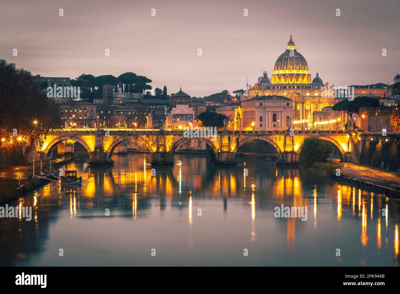 View from the Ponte Umberto I bridge over the Angel Bridge / Pons Aelius / Ponte Sant'Angelo bridge to the Vatican and St. Peter's Basilica in the evening Stock Photo