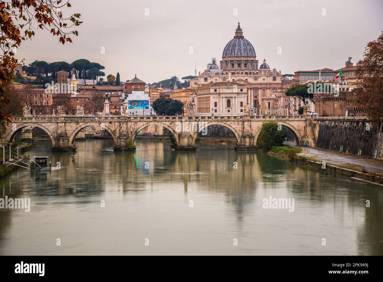 View from the Ponte Umberto I bridge over the Angel Bridge / Pons Aelius / Ponte Sant'Angelo bridge to the Vatican and St. Peter's Basilica in the evening Stock Photo