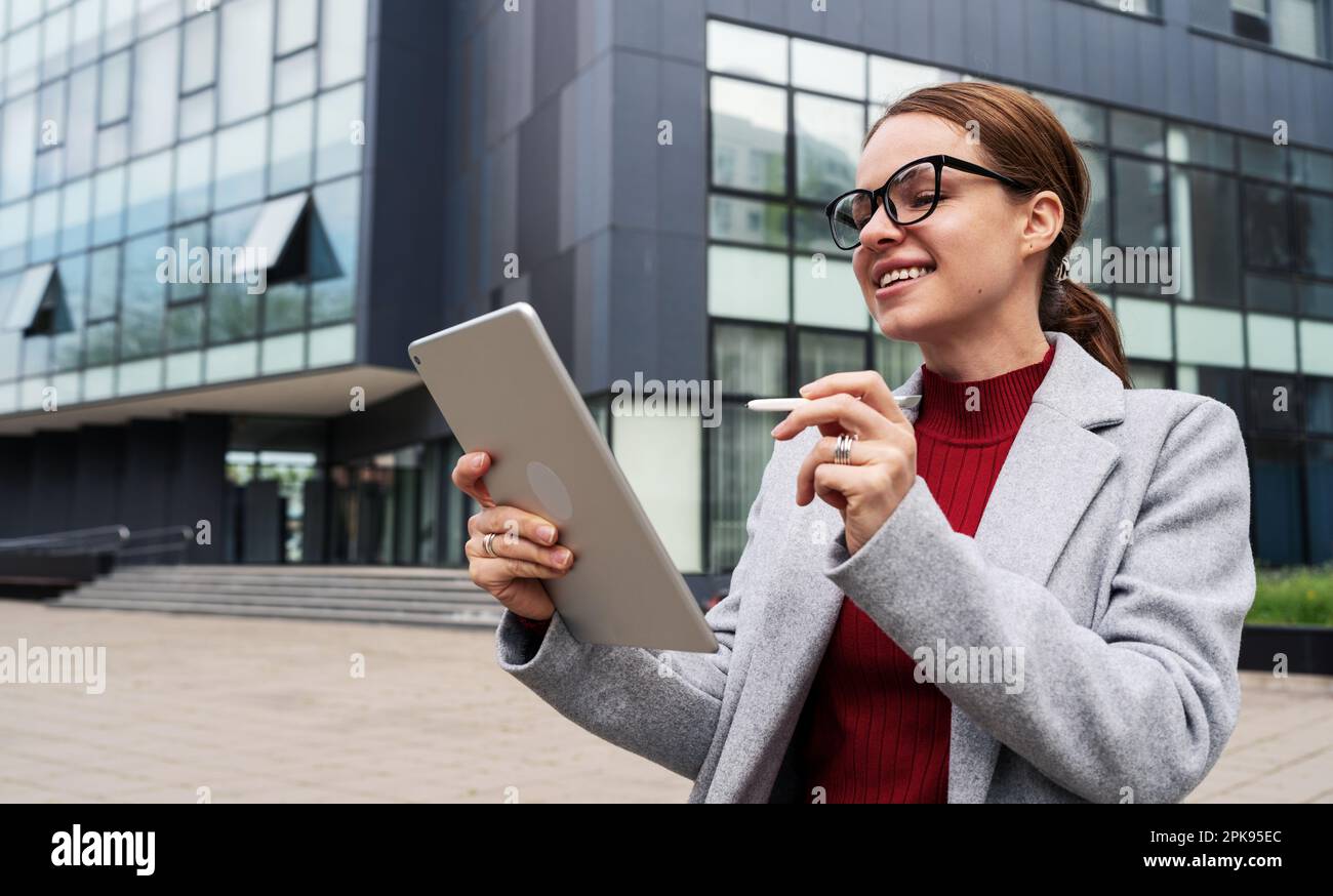 Woman architecture designer creates a new project using her digital tablet and stylus. Stock Photo