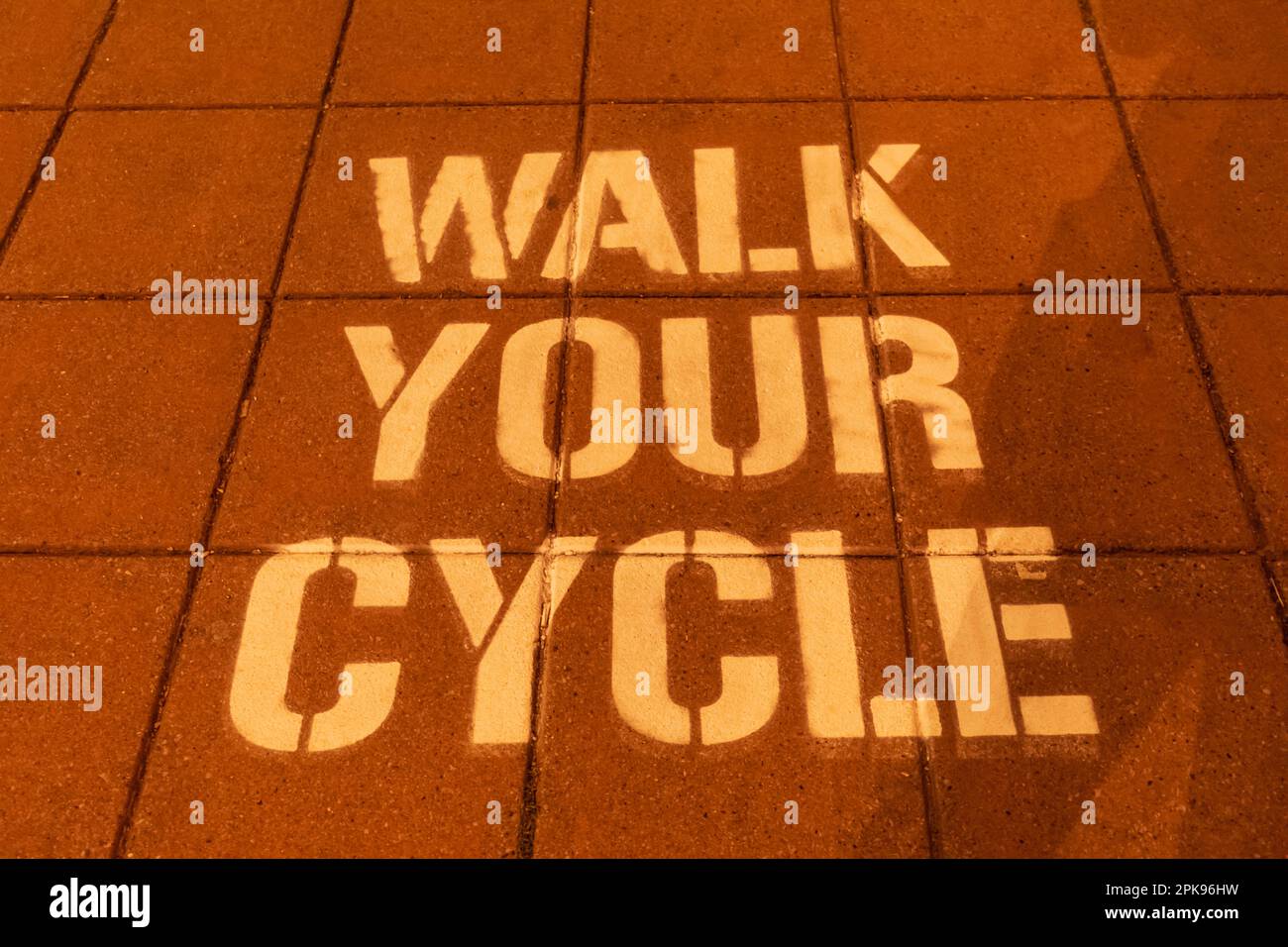 England, East Sussex, Brighton, Walk Your Cycle Sign on Pavement Stock Photo