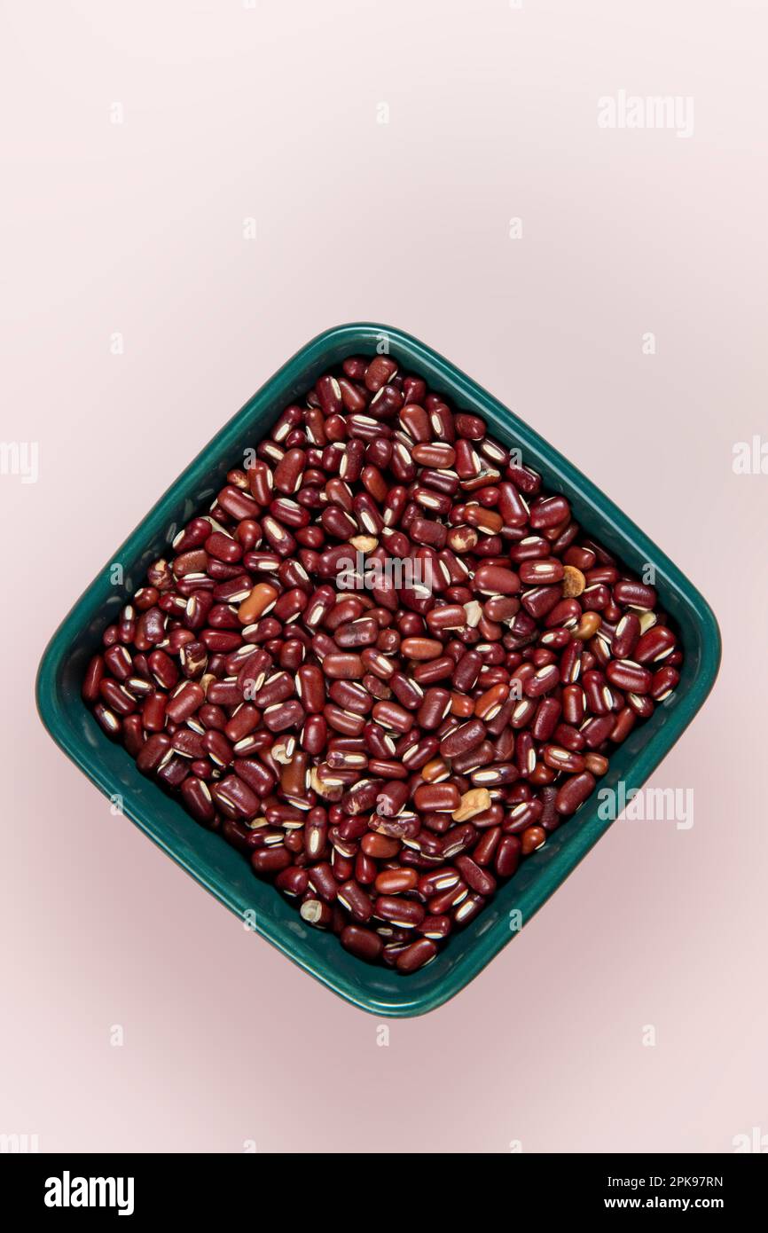 Red azuki bean (Japanese red bean) in bowl isolated on pink background