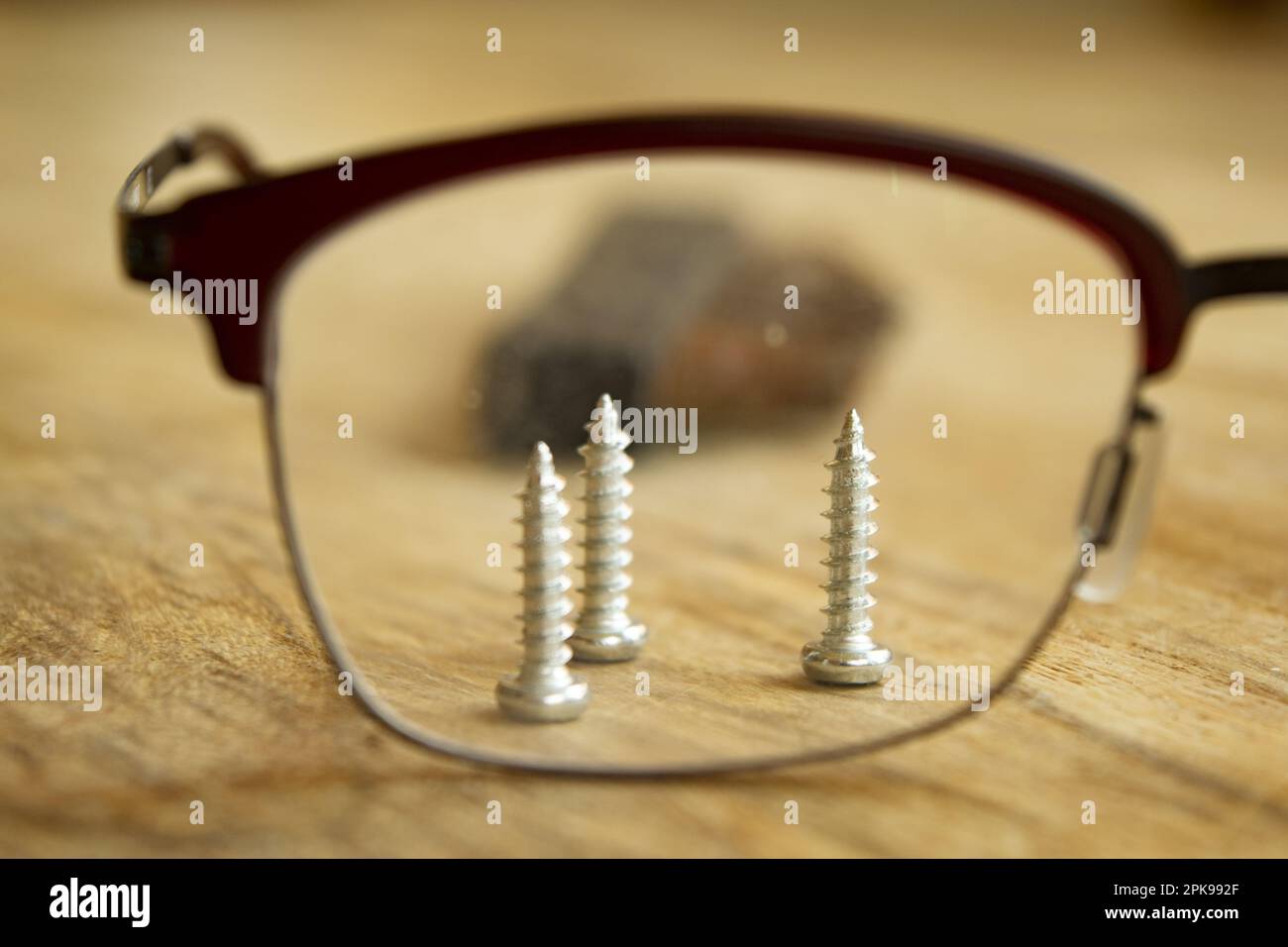 precision handwork concept with screws seen through glasses Stock Photo