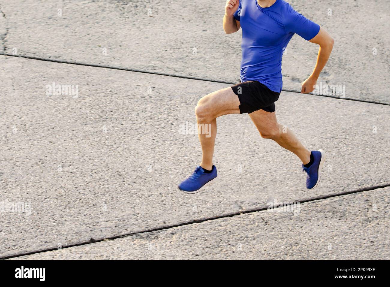 slim muscular male runner running concrete road, top view jogging man ...