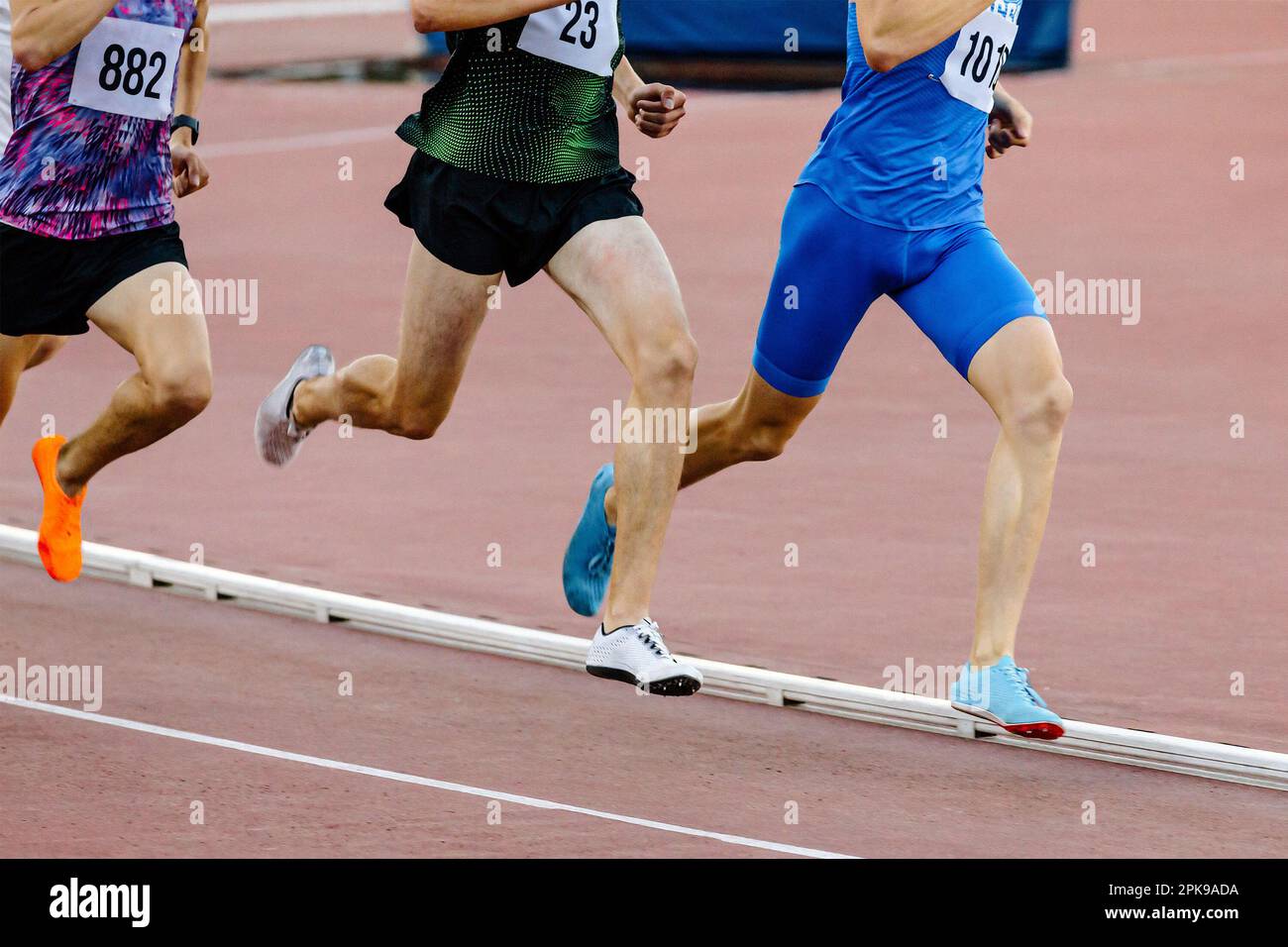 three runners athletes on middle distance running together in track