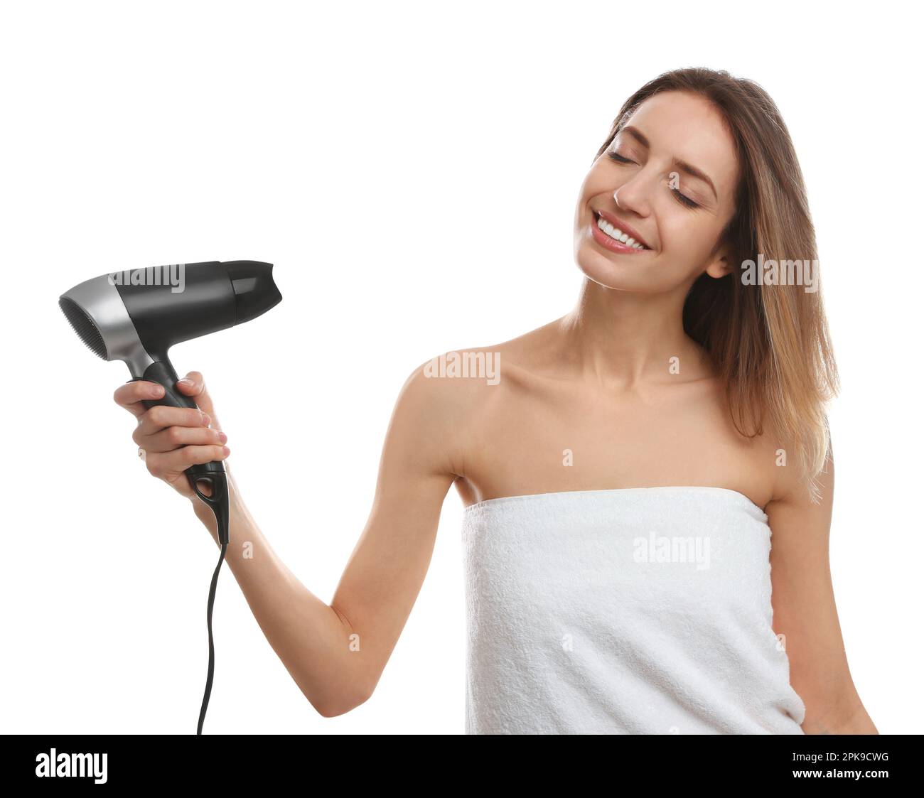Beautiful young woman using hair dryer on white background Stock Photo